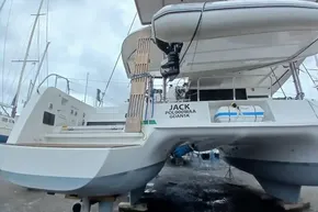 2024 Lagoon 42 catamaran on land, rear view, with lifeboat and equipment.