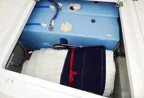 Storage compartment of a 2017 Leopard 45 yacht with blue water tank and folded linens.