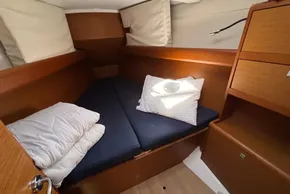 Cozy cabin interior of 2020 Jeanneau Sun Odyssey 389 sailboat with cushions and wooden finish.