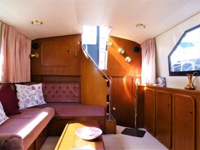 Interior of 1995 Aquafibre Bounty Boats 10/70 with cozy seating and wooden accents.