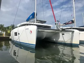 2020 Lagoon 42 catamaran docked at marina, blue sky background.