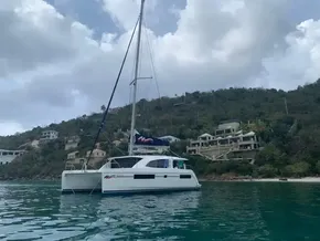 2020 Leopard 40 catamaran anchored near a scenic coastal hillside.