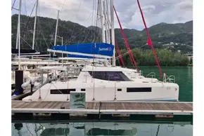 2020 Leopard 45 catamaran docked in a scenic marina with lush green hills.