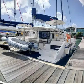 2021 Leopard 40 catamaran docked with inflatable dinghy and marina backdrop.