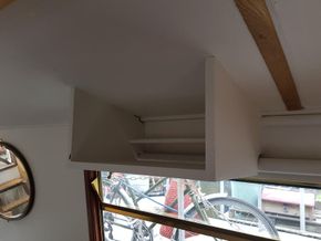 Projector mount aimed at window blind in front of sofa