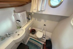 Bathroom interior of 1994 Linssen 360 AC yacht, featuring sink, toilet, and porthole window.
