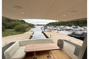 2025 Linssen 45 SL Sedan yacht with elegant teak deck and seating area at a marina.