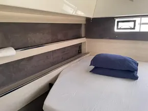 Modern bedroom interior in a 2020 Leopard 50 yacht with blue pillows.