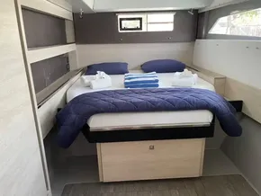 Leopard 50 yacht bedroom, 2020 model, with cozy bed and blue bedding.