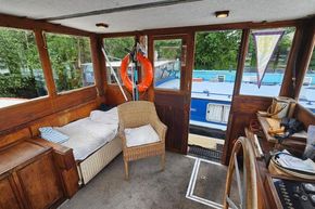1926 Dutch Barge Luxemotor interior with cozy seating, wooden accents, and nautical decor.