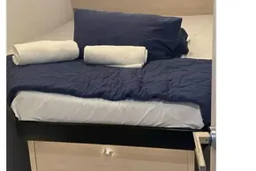 Cozy bedroom in 2020 Leopard 40 yacht with navy bedding and rolled towels.