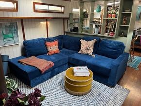 Cozy living area in a 1901 Classic Dutch Barge with blue sofa and vibrant decor.