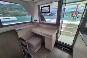 Interior of 2021 Leopard 45 yacht with desk, window view of marina and mountains.