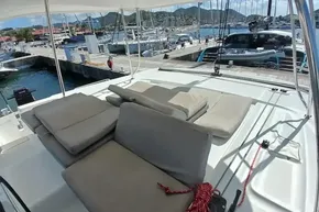 2020 Lagoon 46 catamaran with cushioned seating, docked at a marina.