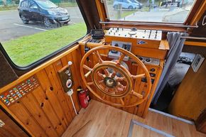 1921 Classic Dutch Barge helm with wooden wheel and control panel.