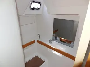 2017 Beneteau Oceanis 38 bathroom with sink, mirror, and porthole window.