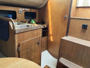 Two ring gas stove in the galley. Light weight non metal propane cylinder stored in the open lazerette.