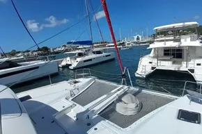 2020 Lagoon 46 catamaran docked in a sunny marina with other boats.