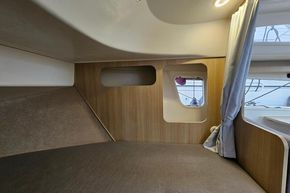 Interior cabin of 2023 Balt 818 Titanium boat with wood paneling and window.