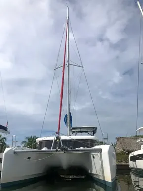 2020 Lagoon 42 catamaran docked at marina under cloudy sky.