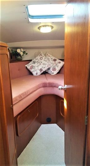 Cozy cabin interior of 1995 Aquafibre Bounty Boats 10/70 with floral cushions.