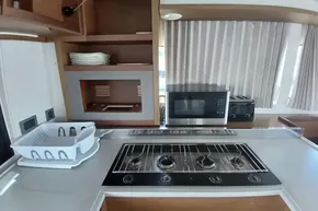 Modern kitchen in 2020 Lagoon 46 yacht with stove, microwave, and dish rack.
