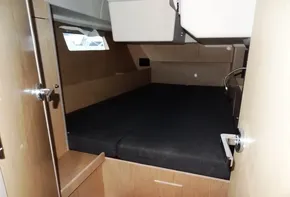 Interior cabin of 2017 Beneteau Oceanis 41 sailboat with wooden finish and black bedding.