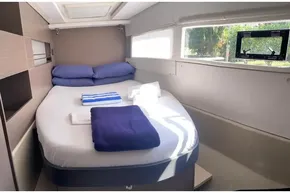 Cozy bedroom interior of 2022 Leopard 45 yacht with neatly arranged bedding.