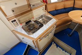 1998 Maxum 2400 SCR boat interior with kitchenette, sink, and seating area.