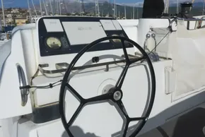 Steering wheel and controls of a 2017 Lagoon 42 catamaran in a marina setting.