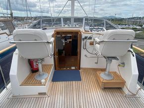 Upper helm - with canopy stowed, view towards companionway to saloon, showing Besenzoni pedestal seats and teak laid deck