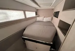 Compact bedroom in 2019 Leopard 45 catamaran with double bed and storage.