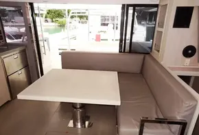 Interior seating area of a 2020 Leopard 43 Powercat yacht with a dining table.