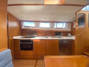 Galley - view from dining area, showing teak veneered base and locker units, oven, hob, fridge-freezer