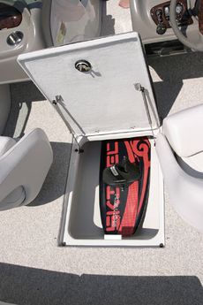 Crownline Bowrider 200 LS Oversized flip-up wakeboard and ski storage compartment at walk-thru access between helm and passenger seats. Features stainless steel shocks.