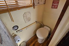Bathroom interior of a 1927 Classic Dutch Barge with toilet and decorative elements.