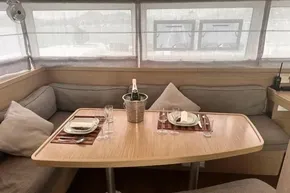 Luxurious interior of 2024 Lagoon 42 yacht with elegant dining setup and champagne.