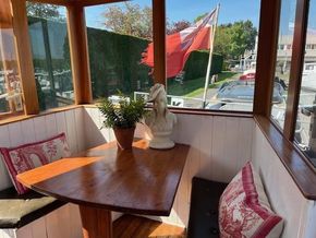 Cozy seating area on a 1901 Classic Dutch Barge with wooden table and decorative pillows.
