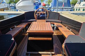 Luxurious 2008 Menken Maritiem The Cab motor yacht interior with wooden seating and steering wheel.
