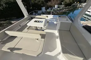 2024 Leopard 40 Powercat deck with seating and table, docked by a serene waterfront.