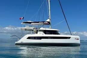 2022 Leopard 42 catamaran sailing on calm waters under a clear blue sky.