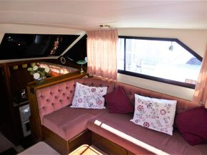 Cozy interior of 1995 Aquafibre Bounty Boats 10/70 with floral cushions and soft lighting.