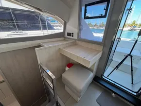 Interior of a 2019 Leopard 40 yacht with seating and desk, overlooking marina.