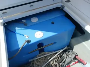 Blue water tank in Leopard 45 yacht storage compartment, surrounded by ropes and equipment.