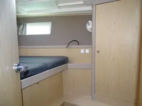 Interior cabin of 2017 Beneteau Oceanis 45 yacht with wooden finish and bed.