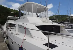 2020 Leopard 43 Powercat docked at marina with lush green hills in background.