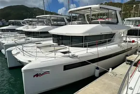 2025 Robertson and Caine Leopard 46 Powercat docked in a marina, surrounded by hills.