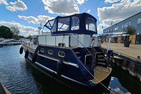 2005 Stevens 1200 Vlet boat docked at marina under partly cloudy sky.
