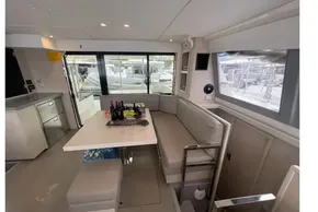 Modern interior of 2020 Leopard 40 catamaran with dining area and beverages on table.