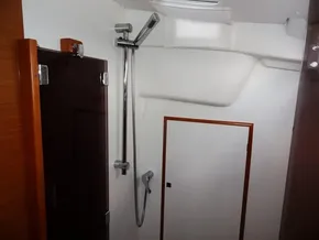Bathroom of 2017 Jeanneau Sun Odyssey 389 sailboat with shower and wooden door.